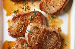 overhead view of Pork Chops with Apple Cider Glaze recipe sprinkled with fresh rosemary leaves