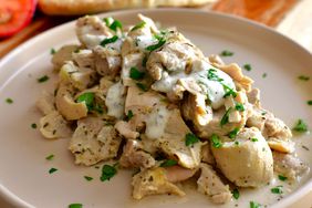 white rimmed plate with chopped chicken in yogurt sauce