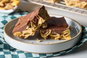 A plate with no-bake peanut butter Chex bars shown in front of a cooling rack with additional bars