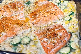 baking dish of creamy orzo, corn, and zucchini with salmon filets