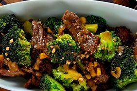 steak and broccoli stir fry in an oval white dish on cutting board