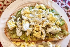 overhead view of toast with avocado and chopped boiled egg on white plate
