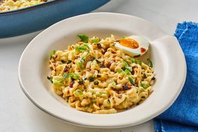 A bowl of buldak ramen casserole topped with a halved boiled egg