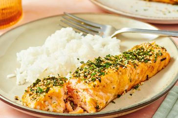 Plate with furikake seasoned salmon and a side of white rice fork placed near the food