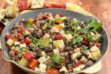skillet with ground turkey and vegetables on table with towel