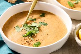Bowl of creamy lentil soup garnished with fresh mint.