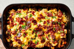 looking down at a buffalo chicken and roasted potato casserole, garnished with sliced green onions.