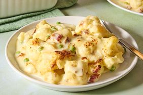 Plate of cauliflower alfredo bake with peas and a fork