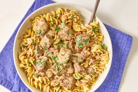 overhead view of beef stroganoff and noodles on periwinkle napkin