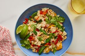 Looking down at a serving of sticky coconut chicken and rice casserole, served in a bowl. 