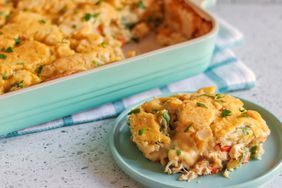 Scoop of Chicken Cobbler on a green plate next to a baking dish 
