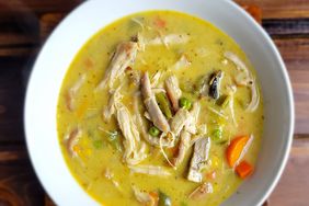 overhead view of creamy pot pie chicken soup with vegetables in white bowl