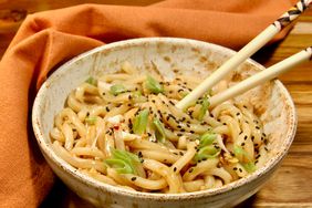 bowl of udon noodles with chopsticks and orange napkin