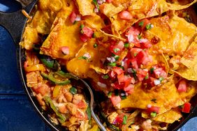 Chicken fajita casserole in a skillet with melted cheese and diced tomatoes on top