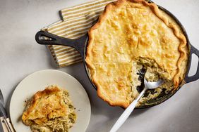 White Chicken Chili Pot Pie in a cast iron skillet with a severing spoon, next to more pie on a plate 