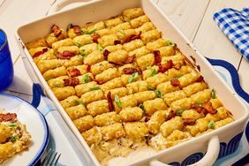 Chicken Bacon Ranch Casserole Tater Tot Casserole garnished with bacon and green onions in a baking dish, next to a plate 