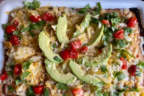 overhead view of picadillo casserole with cornbread and cheese, avocado, tomatoes and cilantro
