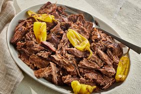 A platter of Mississippi roast (slow cooker pepperoncini pot roast), topped with pepperoncinis
