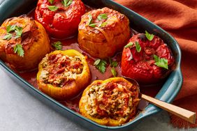 A baking dish with beef and rice stuffed bell peppers, garnished with chopped parsley 