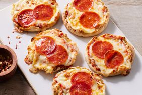 A platter of fast English muffin pizzas topped with melted cheese and pepperoni