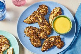 Chicken strips with seasoning and a dipping sauce on plates