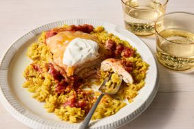A plate of salsa chicken topped with sour cream and served over yellow rice