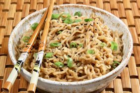 Miso butter ramen noodles in bowl with chopsticks and topped with green onions and sesame seeds