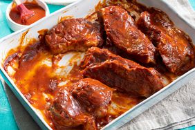 high angle view of saucy BBQ ribs served in a white baking dish
