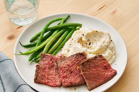 rib eye roast served with mashed potatoes and green beans