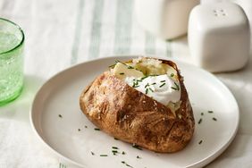 an air fryer baked potato topped with butter and sour cream