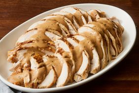 high angle looking at a platter of sliced turkey breast topped with gravy