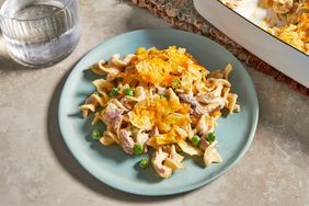 a high angle view of a plate of the best tuna noodle casserole with the casserole dish sitting nearby