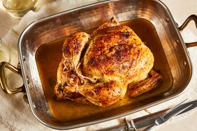 an overhead view of a beautifully roast chicken in a roasting pan.