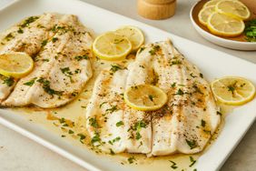close up on a few trout fillets with lemon slices on top