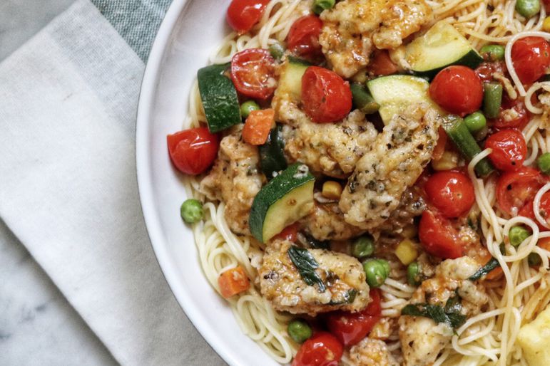 top-down view of chicken primavera on angel hair pasta