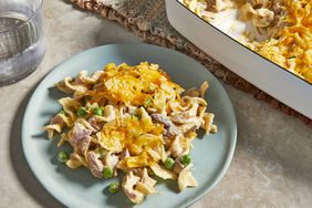 a high angle view of a plate of the best tuna noodle casserole with the casserole dish sitting nearby