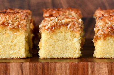 3 slices of cake up close side view vanilla cake with broiled coconut icing on board