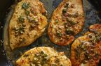 looking down at a few pieces of chicken piccata in a skillet