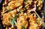 Chicken pieces on a bed of apple stuffing garnished with fresh herbs
