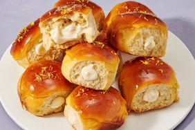 A plate of stacked lemon cheesecake creme brulee donuts, topped with lemon zest