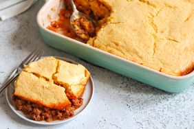 Sloppy Joe Cornbread Casserole on a plate with a fork next to a baking dish