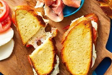an overhead shot of air fryer proscuitto and mozzarella grilled cheese on a wood board