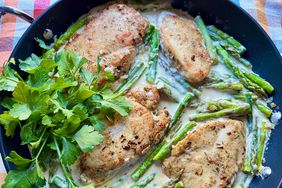 overhead view of skillet with chicken and asparagus in creamy lemon sauce