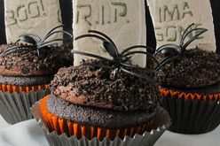 Halloween cupcakes decorated with plastic spiders and cookie tombstones