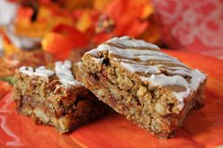 Two blonde bars with stripes of confectioners' sugar icing on an orange plate with fall leaf decor in the background