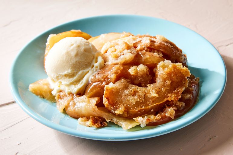 A bowl of apple betty served with vanilla ice cream